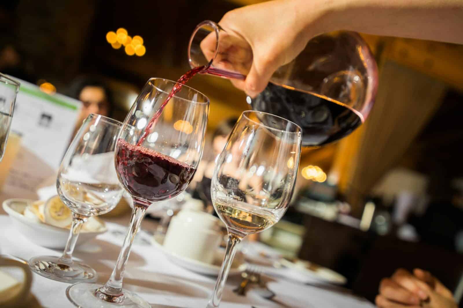 Hand pouring red wine to glass