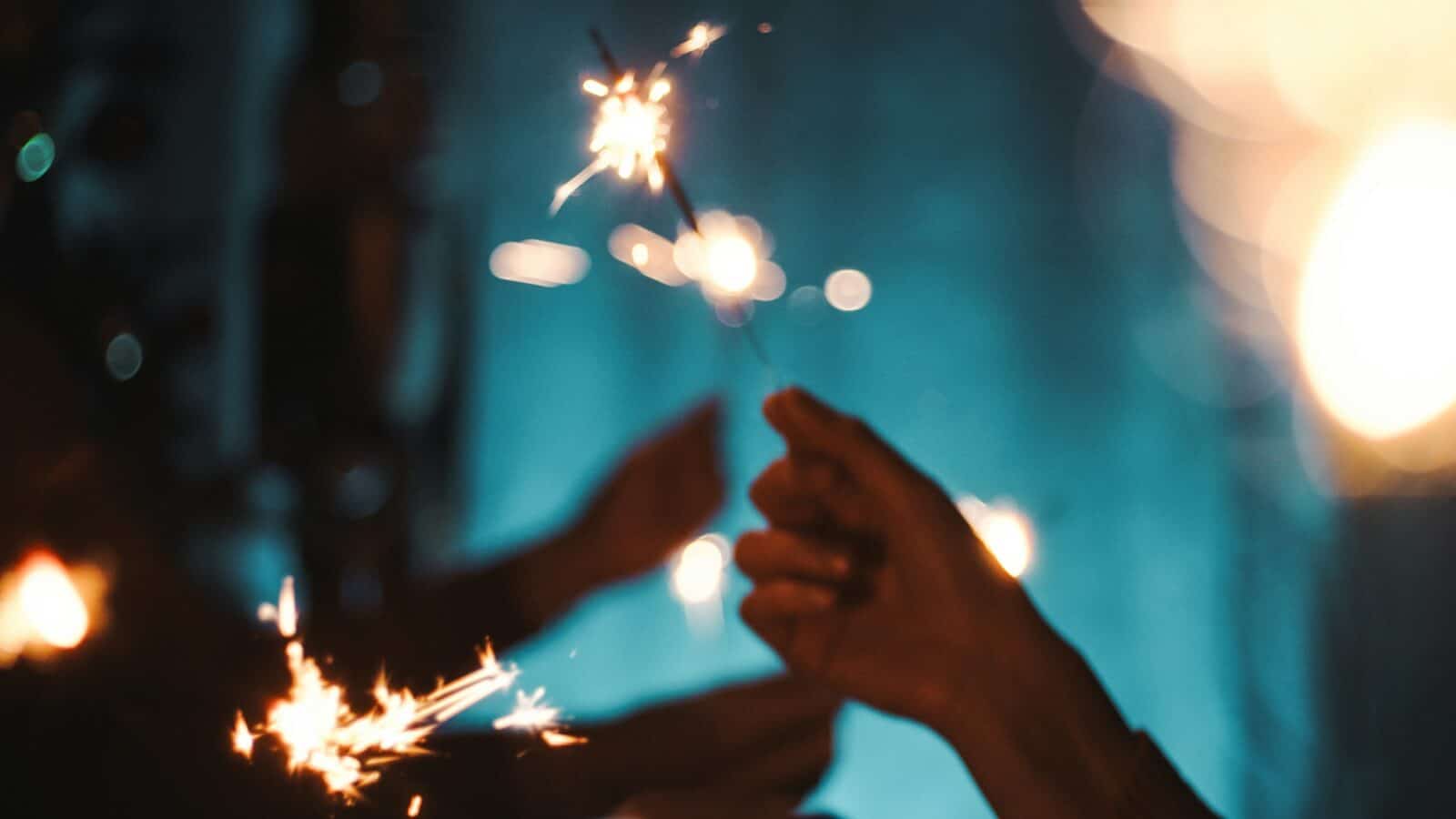 Silhouette of hands waving sparkles for new year event party